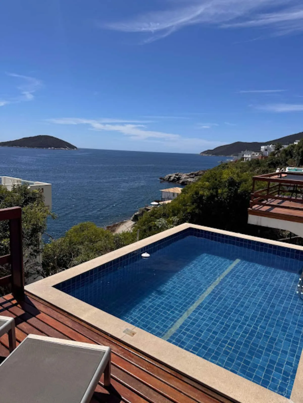 Piscina azul da casa vista de cima com o mar do Pontal do Atalaia ao fundo
