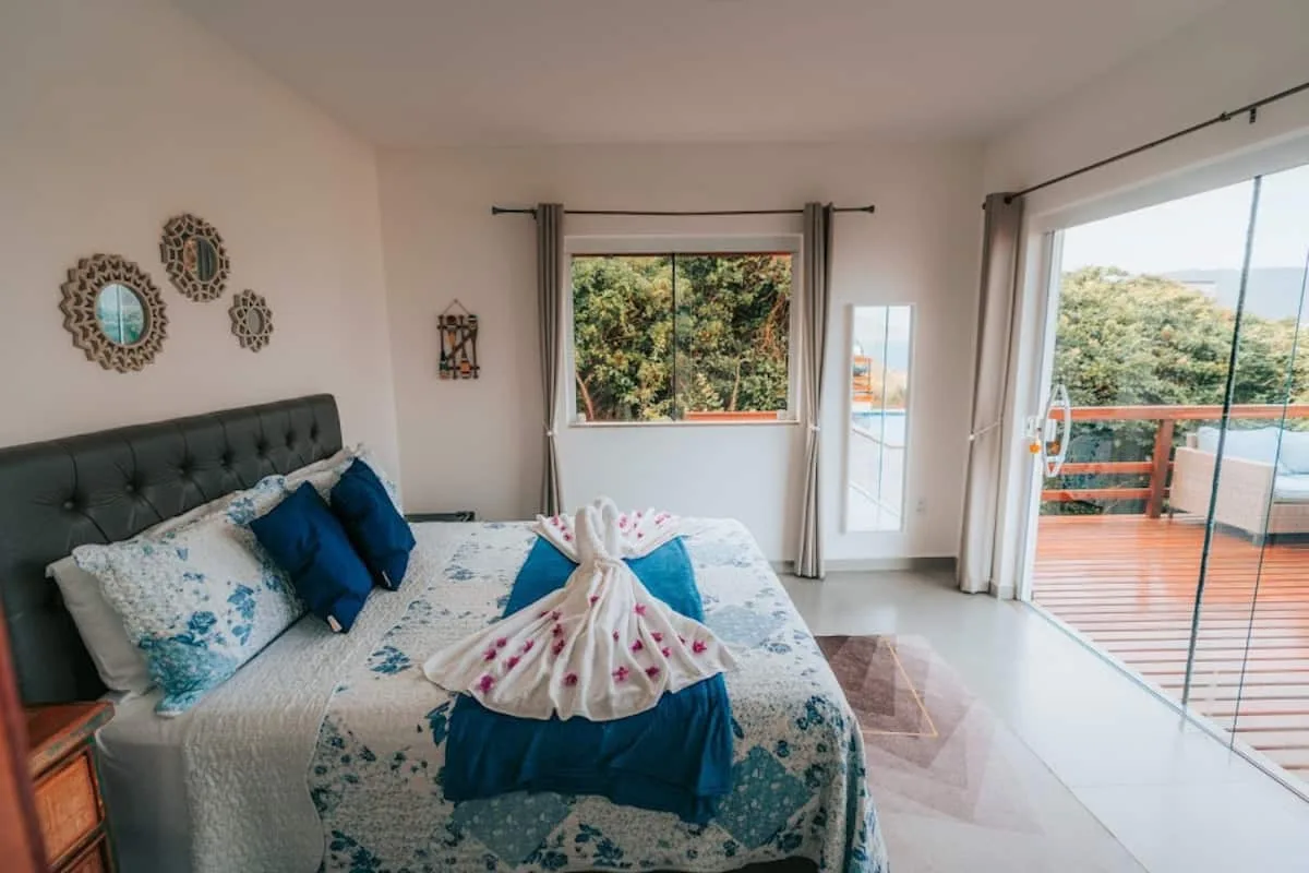 Suíte principal com cama queen e vista para o mar