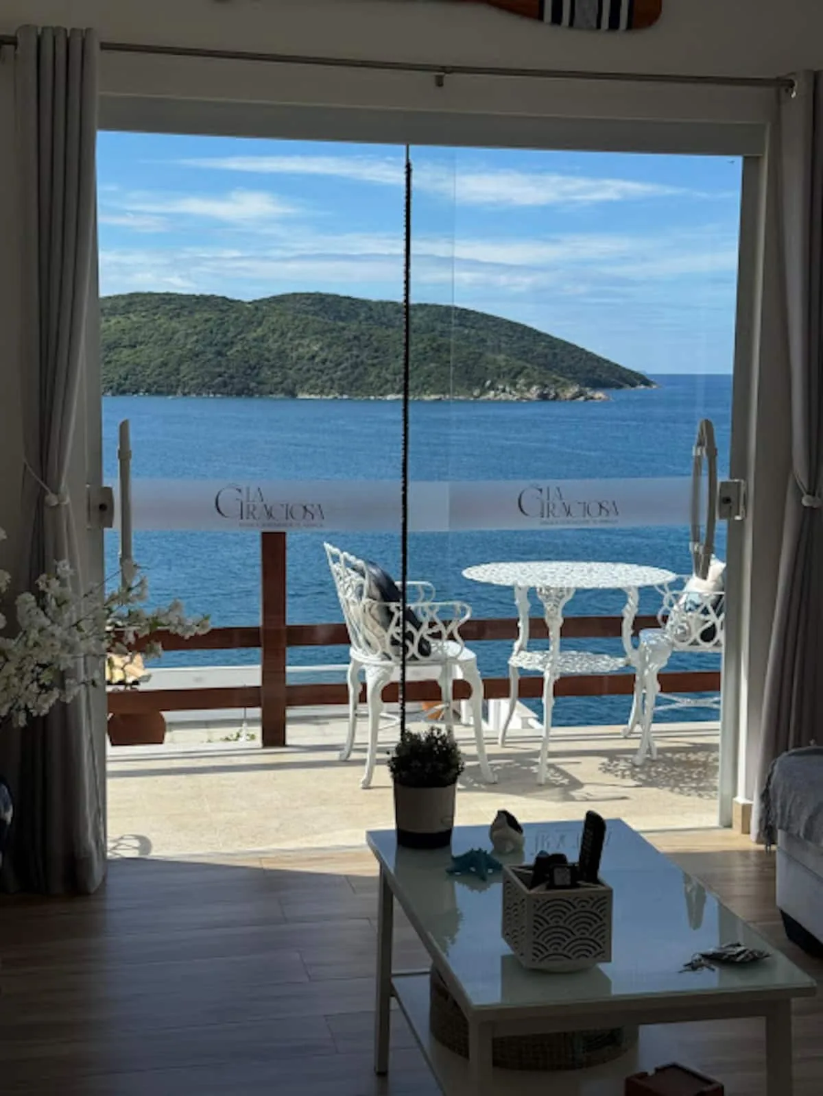 Sala integrada com mesa na varanda e vista para o mar