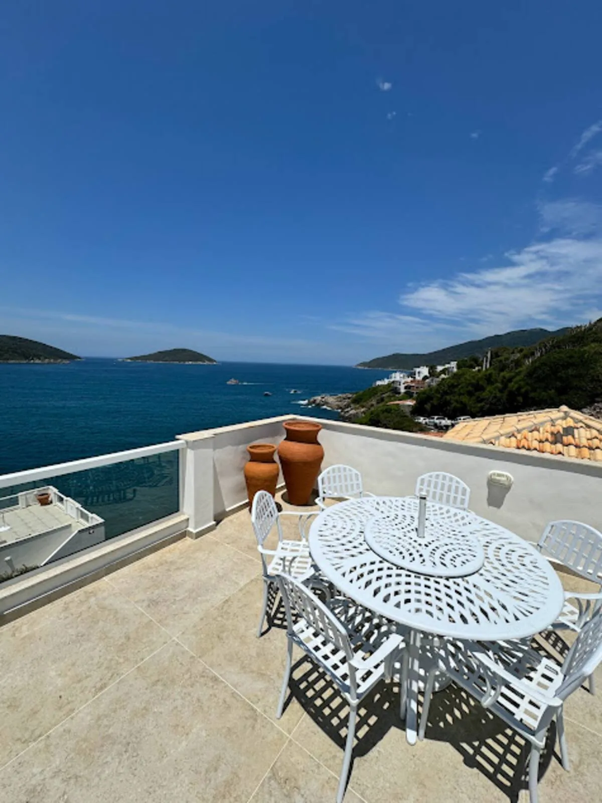 Área do terraço com mesa e vista para a enseada