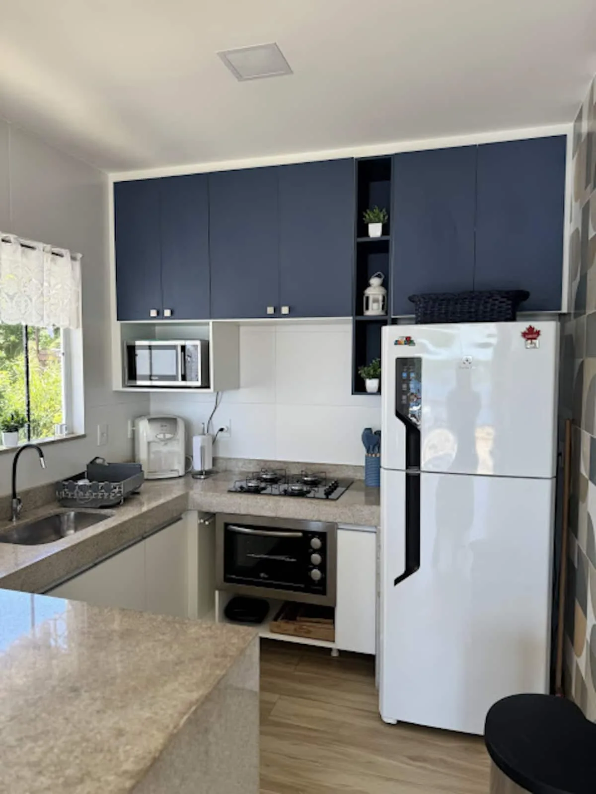 Cozinha com fogão, geladeira e armários azuis